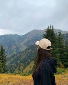 a woman standing on top of a lush green hillside