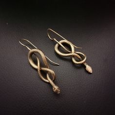 Snake Earrings in Brass.  Available in Gold and Silver colour. Silver colour earrings are Brass Plated with Silver. Dimension (approx)  Total drop: 6.5 cm Width: 2 cm One piece weighs around 9 grams (approx 18grams for 1 pair) Snake Shaped Single Earring As Gift, Single Snake Shape Earring As Gift, Snake Shaped Single Earring For Gift, Snake-shaped Earrings With Ear Wire As Gift, Gold Snake Jewelry For Pierced Ears, Handmade Elegant Snake Earrings, Snake-shaped Earrings With Ear Wire For Gift, Elegant Handmade Snake Earrings, Nickel-free Unique Snake-shaped Jewelry