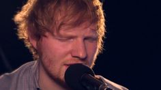 a close up of a person singing into a microphone