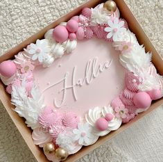 a pink and white cake in a box with the name halia on it's side