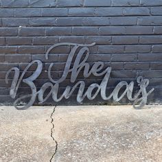 the sign is next to a brick wall that says, the badday's