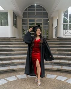 a woman in a graduation gown and cap is posing for the camera