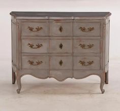 an antique chest of drawers with marble top in grey and gold leaf pattern, on white background