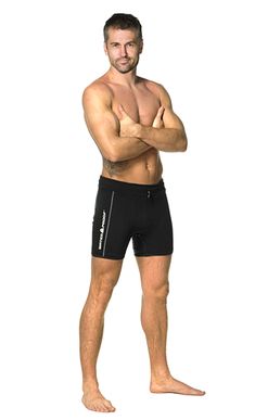 a man standing with his arms crossed in front of the camera, wearing black trunks and no shirt