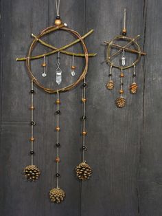 an assortment of pinecones hanging on a wooden wall with beads and chains attached to it