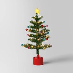 a small christmas tree in a red container with lights on it and a star on top