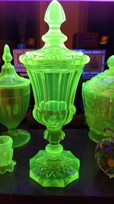 green glass vases and bowls are sitting on a table