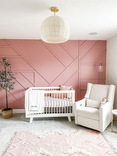 a baby's room painted in pink and white with a crib next to it