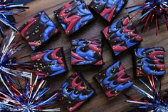 some red white and blue treats are on a wooden table with tinsel sprinkles