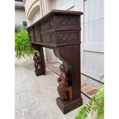 two wooden statues sitting next to each other in front of a building