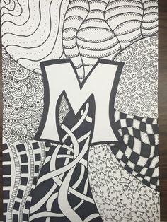 the letter m is made up of black and white lines, with an abstract design