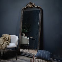 a chair sitting in front of a large mirror