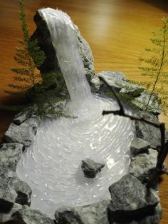 a water fountain made out of rocks on a table