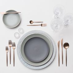 a table setting with silverware, plates and utensils