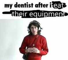 a man with long hair wearing a red shirt and headphones, standing in front of a white wall