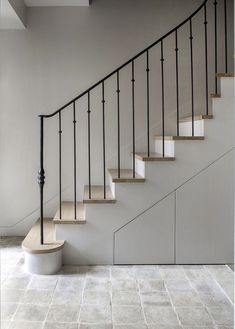 a white staircase with black railing and handrail