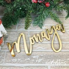 a christmas decoration with pine branches and presents on the floor next to it is an ornament that says, merry