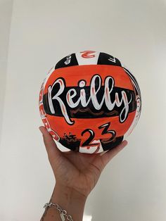 a person holding up a ball with the word really on it in front of a white wall