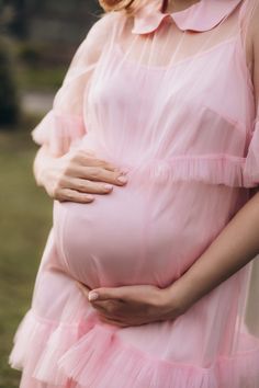 Introducing our stylish and versatile maternity dress. It features a loose and romantic cut, perfect for any occasion. The dress consists of two parts: a combination of an adjustable-strap underdress and a soft tulle overlay adorned with elegant ruffles. It's ideal for baby showers, weddings, or any special event. With its midi length and convenient button closure at the back, it offers both comfort and style. Made from a body-friendly viscose fabric, this dress is designed to be worn during and Pink Nursing Friendly Maternity Dress For Spring, Pink Nursing-friendly Maternity Dress For Spring, Spring Pink Nursing-friendly Maternity Dress, Spring Nursing-friendly Pink Maternity Dress, Spring Maternity Dress In Pink, Nursing Friendly, Pink Nursing Friendly Maternity Dress, Summer Nursing-friendly Maternity Dress, Pink Maternity Dress With Ruffles, Feminine Ruffled Maternity Dress