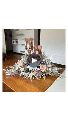 an arrangement of flowers and candles on a table