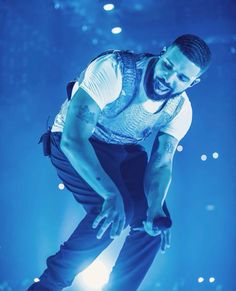 a man in white shirt and blue pants on stage