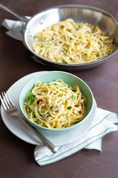 two bowls filled with pasta on top of a table