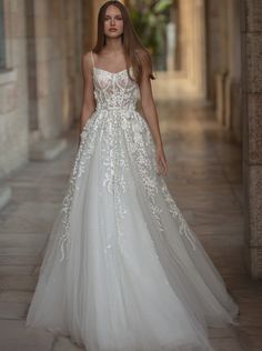 a woman in a white wedding dress is walking down the street