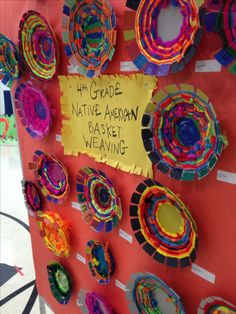 a bulletin board with paper plates on it and a sign that says 4th grade native american weaving