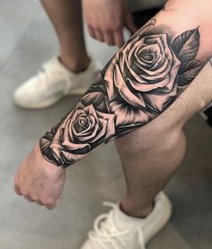 a man's arm with roses on it and his leg is shown in black ink