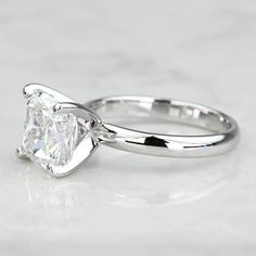 a white gold ring with a princess cut diamond