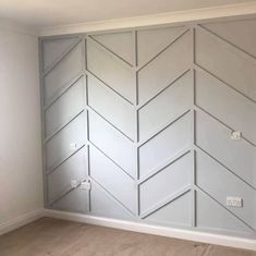 an empty room with white painted walls and wood flooring in the middle of it