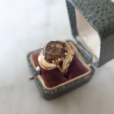 This crazy free form ring from circa 1960 is such a delight. Fabricated in 10kt gold custom, this ring features a large faceted tested smokey topaz round stone. The setting winds its way around the stone and sets it up. The ring looks like an eye or from the side view a lovely place for to view the whole stone. The mark on this ring has all been worn off but a k is still visable where it would have been marked 10kt. The ring has been tested non the less. Currently a size 7.5 a rather fantastic f Smokey Topaz Ring, Freeform Ring, Fantasy Ring, Smokey Topaz, Retro Ring, Topaz Ring, Ring Vintage, Side View, Statement Ring