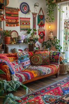 a living room filled with lots of colorful rugs and plants on the wall next to a window