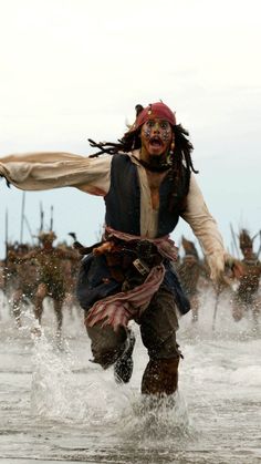 a pirate running through the water with his arms outstretched