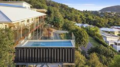 an aerial view of a house with a swimming pool in the foreground and mountains in the background