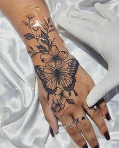 a woman's hand with a butterfly tattoo on it