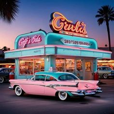 an old pink and blue car parked in front of a restaurant at dusk with palm trees