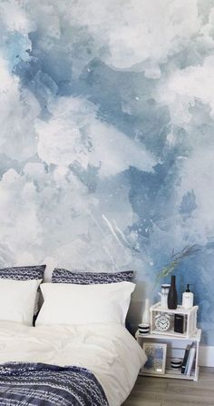 a bedroom with blue and white paint on the wall, bedding and nightstands