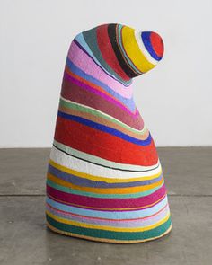 a multicolored sculpture sitting on top of a cement floor