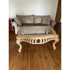 a living room with a couch and a glass coffee table on top of wood flooring