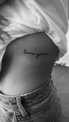 a woman's stomach with the word love written in cursive writing on it