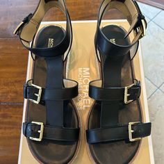 Michael Kors Cunningham Sandal Black Leather With Gold Buckle 1 Inch - Raffia Platform Like New In Box Michael Kors Casual Ankle Strap Sandals, Michael Kors Leather Sandals With Cushioned Footbed, Elegant Michael Kors Platform Sandals, Michael Kors Black Round Toe Sandals, Michael Kors Black Flat Sandals, Michael Kors Black Leather Sandals, Cork Shoes, Michael Kors Open Toe Sandals With 4-inch Heel, Michael Kors Black 4-inch Heels