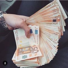 a person is holding money in their hand