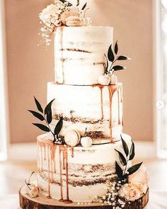 a wedding cake with dripping icing and flowers