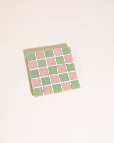 a piece of pink and green paper sitting on top of a white table