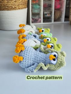 several crocheted birds are lined up in a row on the floor next to a basket