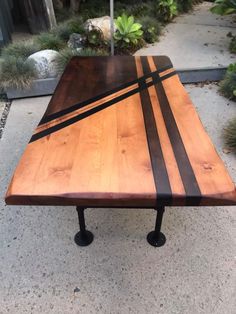 a wooden table sitting on top of a sidewalk