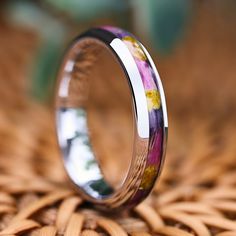 a ring with flowers painted on it sitting on top of a wicker tablecloth