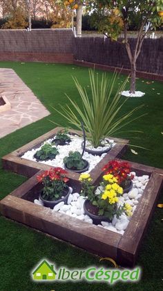 a wooden planter filled with lots of flowers on top of a lush green field