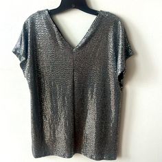 Metallic Silver V-Neck Top Size Small Short Sleeve Over- Sized 45% Nylon 45% Poly 10% Spandex V Neck Is Slightly Lower In Back Brand: Carmela Never Worn Smoke Free Home Chic Silver V-neck Top, Chic Metallic V-neck Top, Metallic V-neck Top For Summer, Metallic Fitted V-neck Top, Metallic V-neck Top For Party, Metallic V-neck Top For Night Out, Metallic V-neck Top For Evening, Stretch V-neck Top For Night Out, Silver V-neck Tops For Night Out